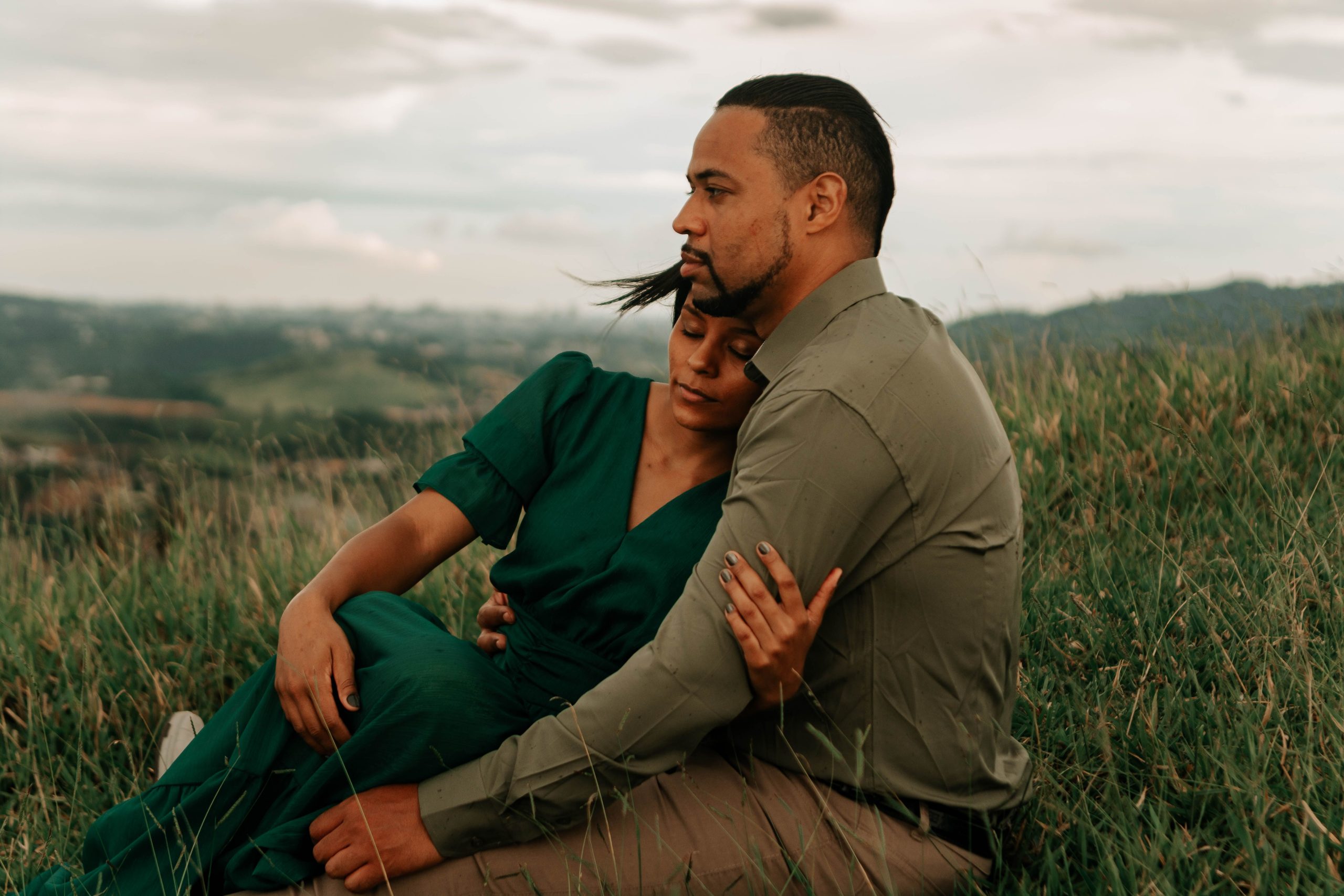 Couple s'enlace tendrement dans une prairie verdoyante