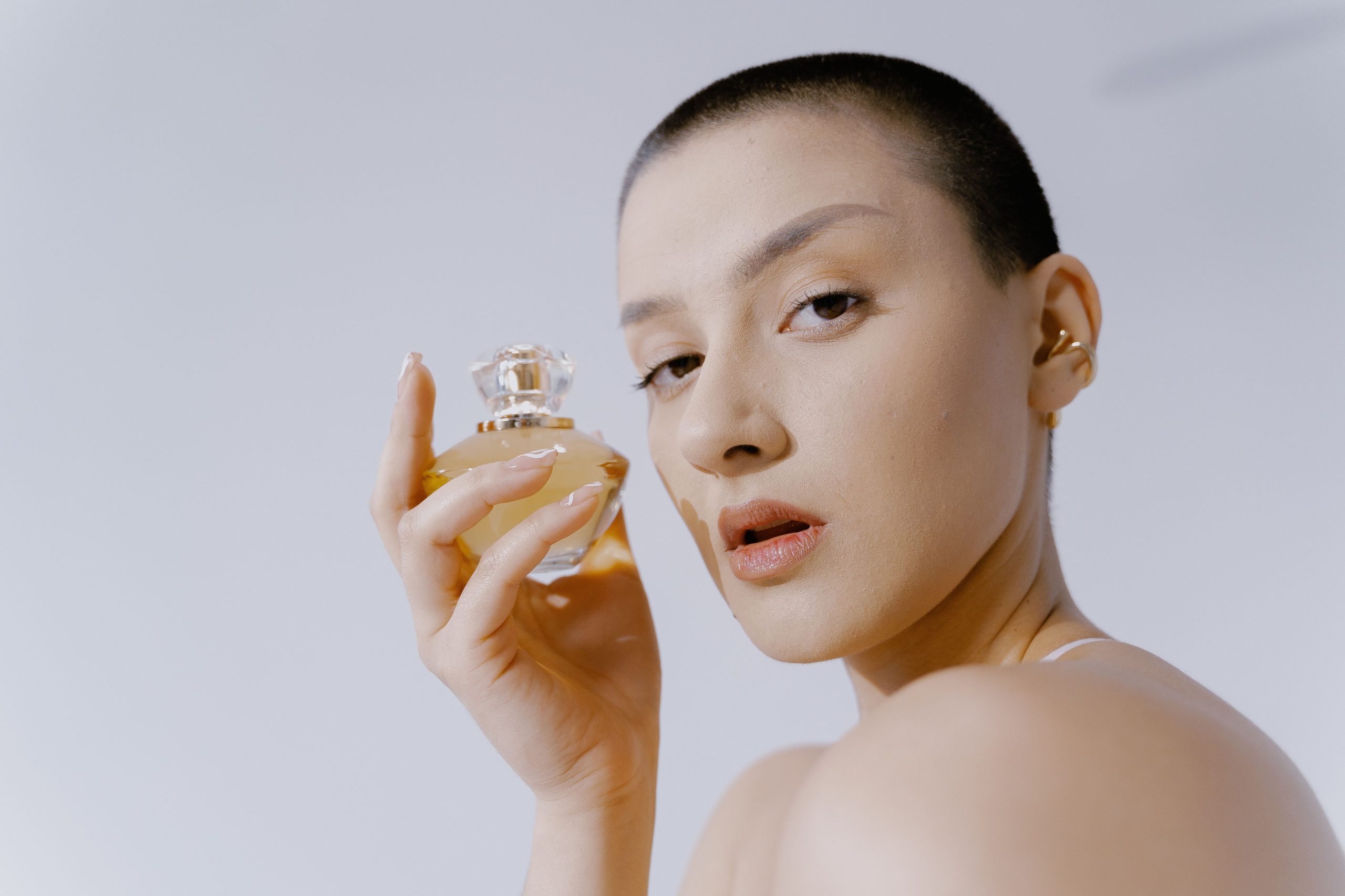 Femme tenant un flacon de parfum elegance