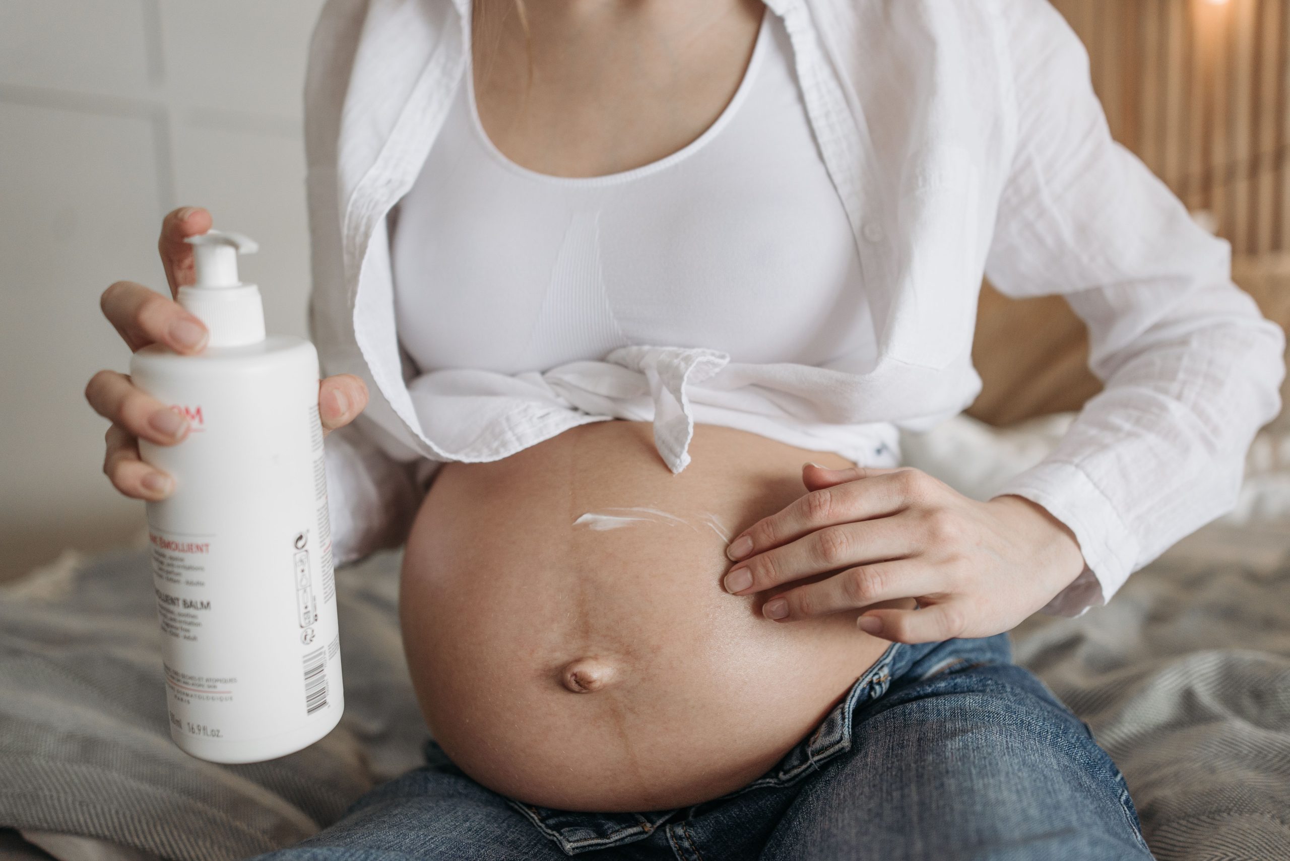 Femme enceinte appliquant lotion sur son ventre