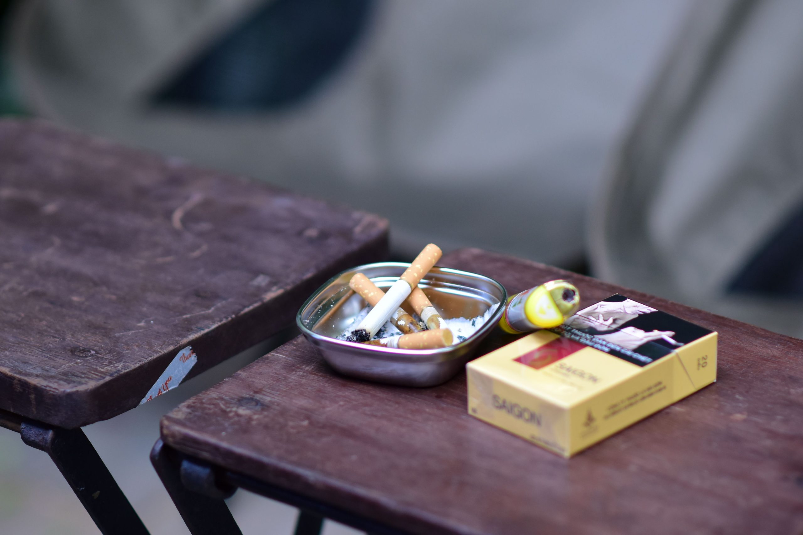 Cendrier avec mégots et paquet sur table