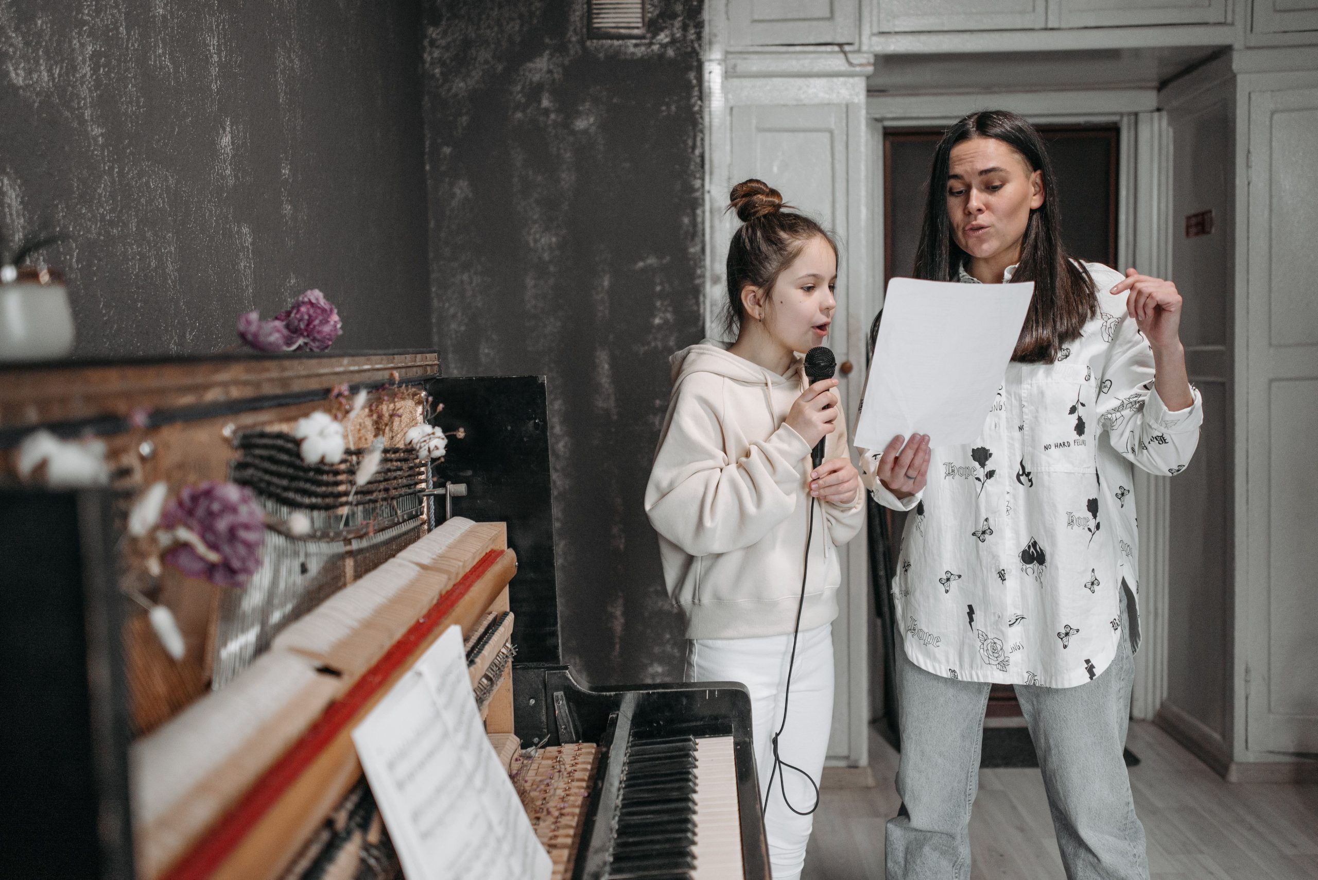Jeune fille chantant avec son professeur et piano
