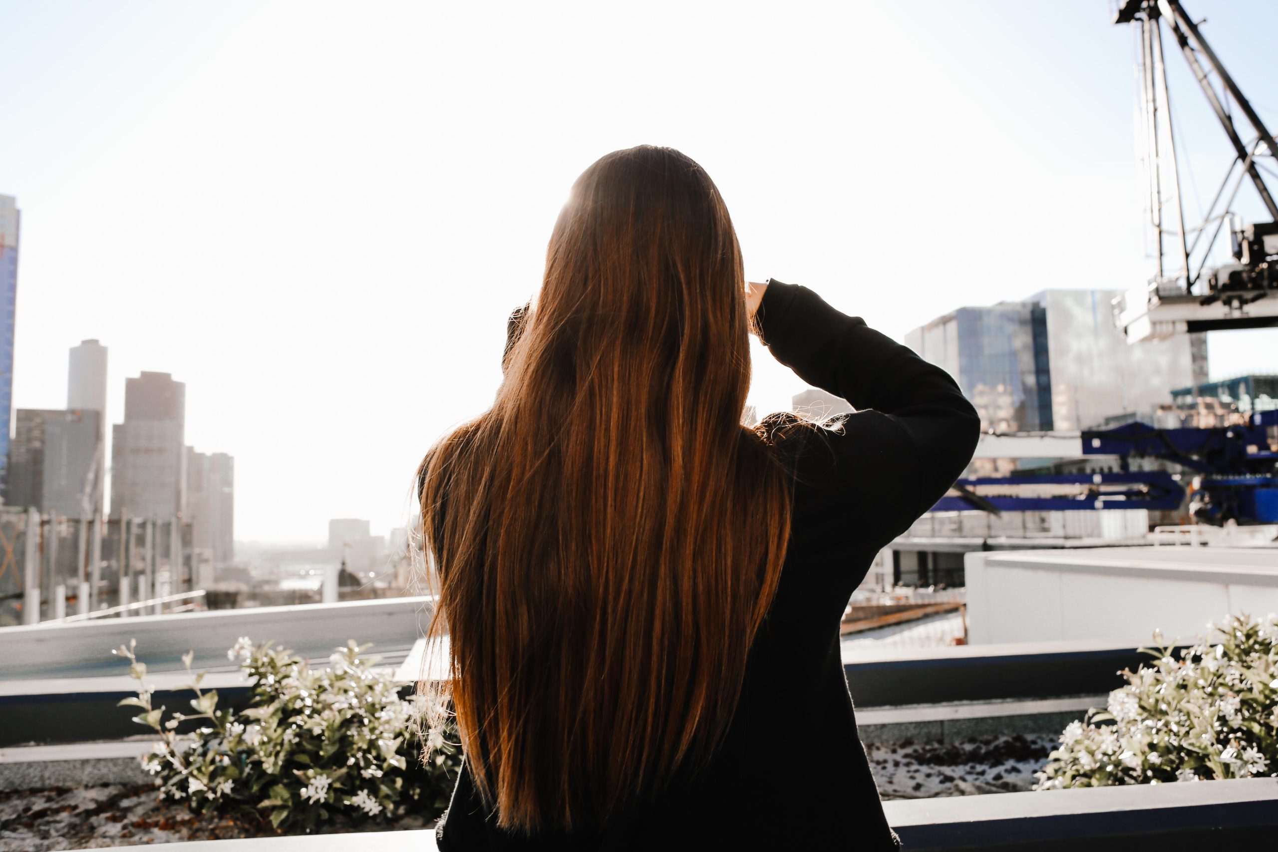 Femme aux longs cheveux bruns vue de dos urbaine