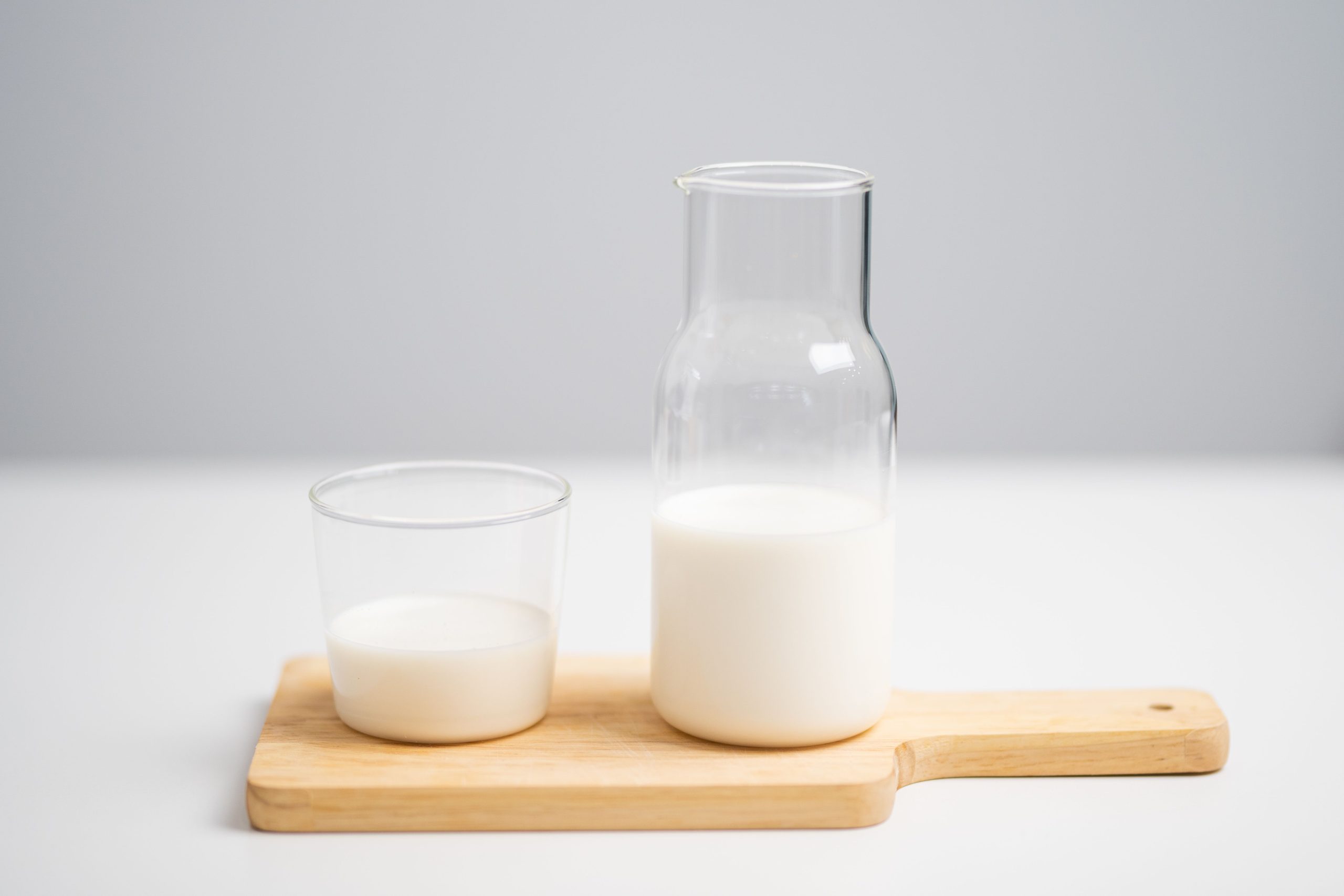 Verre et pichet de lait sur planche bois