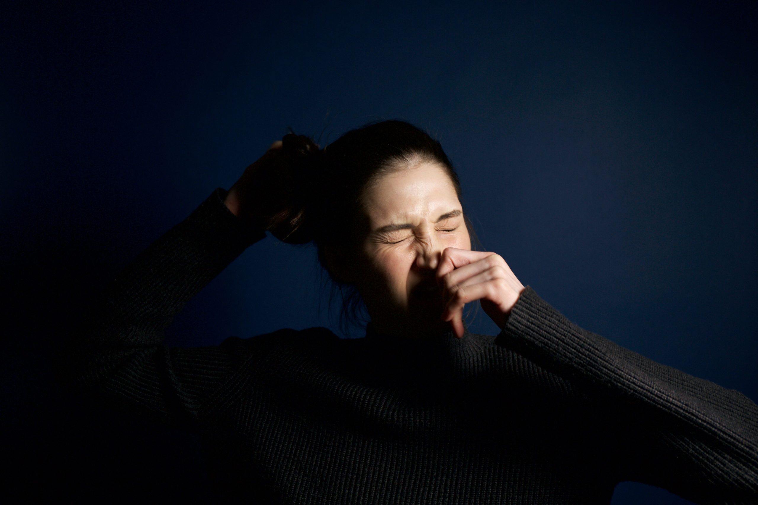 Femme éternuant montrant symptômes allergiques