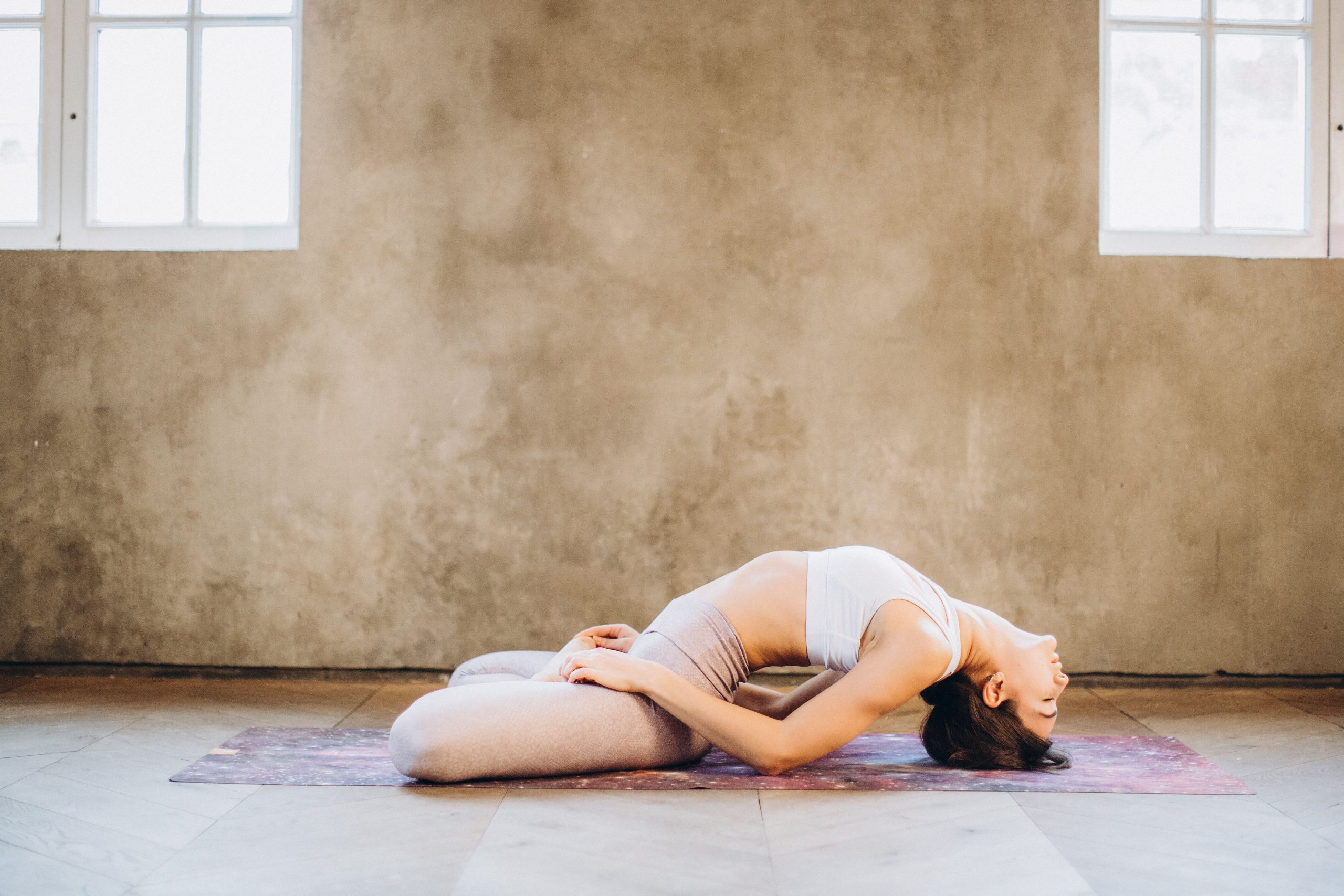 Femme pratiquant une posture de yoga allongée
